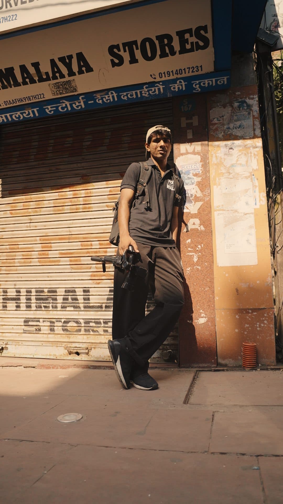 Low-angle shot of a crew member in front of the Himalaya Stores shopfront
